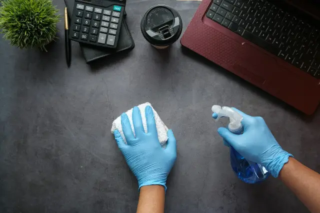 Profesyonel temizlik personeli eldivenle yüzey temizliği yapıyor